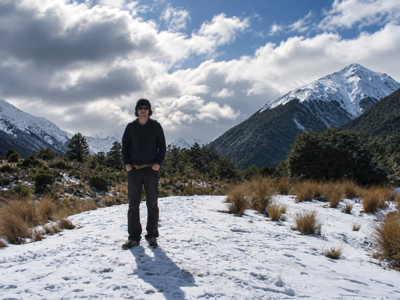 Tom standing in snow beneath the South Island mountains